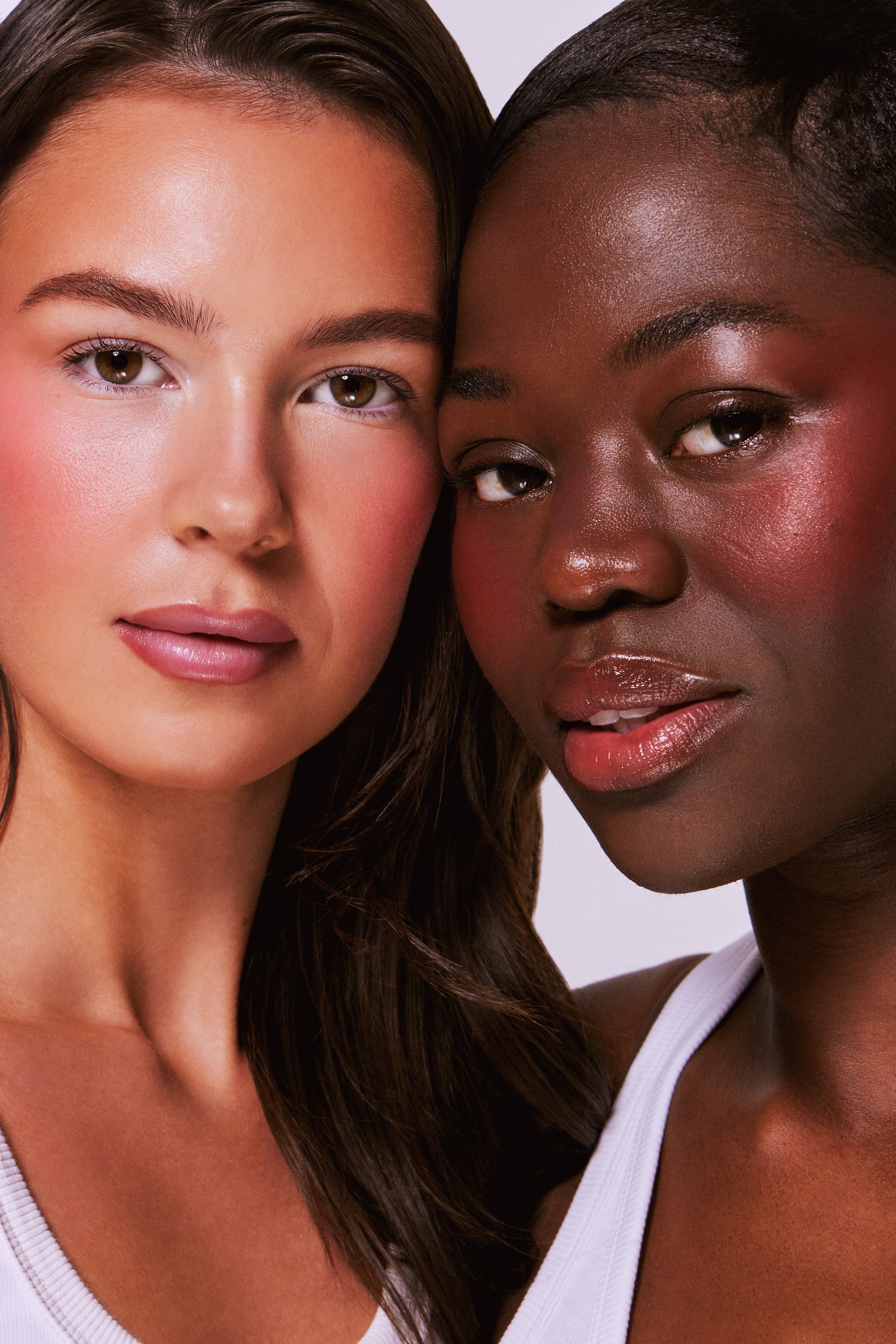 Two women with different skin tones standing close together.